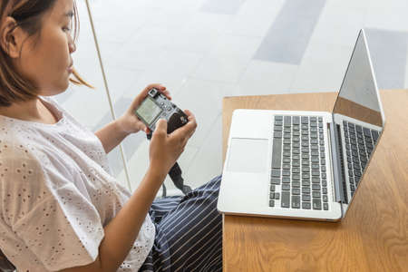 Woman transfer image data on camera to laptopの写真素材