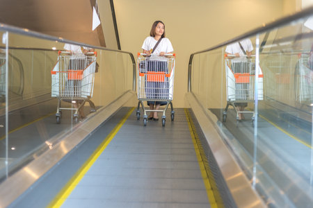 Asian Woman going down from the escalatorの写真素材