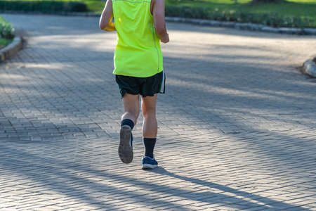 Rear view photo of young man running in the parkの写真素材