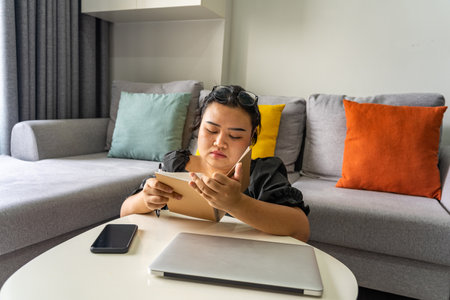 Young woman working at home with laptop in living room areaの写真素材