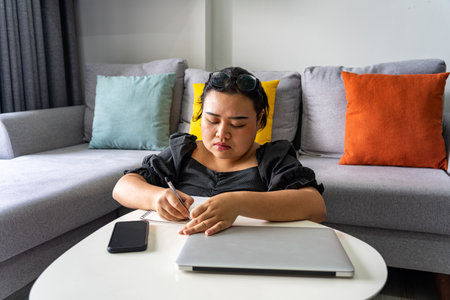 Asian woman writing note and work from home with laptopの写真素材