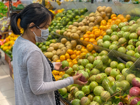 Pregnant woman buying cainito or star apple fruit at fruit storeの写真素材