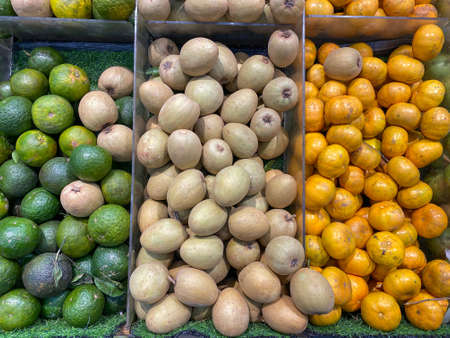Green orange, sapote fruit and tangerine for sale at fruit storeの写真素材