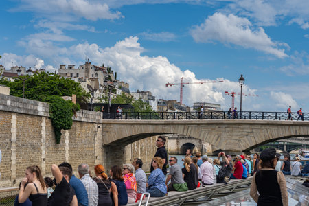 19 June 2019 - PARIS, FRANCE: Tourists enjoy beautiful scene on boat trip along Seine riverのeditorial素材