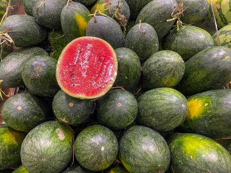 Pile of eclipse shaped red watermelon at fruit storeの写真素材