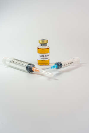 Sars-CoV-2 vaccine bottle and syringes on white backgroundの写真素材