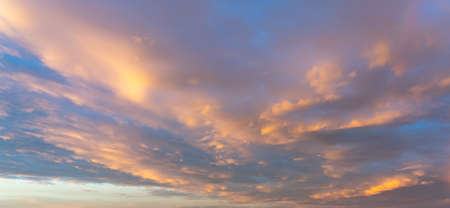 Panorama photo of pink clouds on dramatic sky at sunsetの写真素材