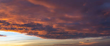 Fiery orange cloud on dramatic sky at sunsetの写真素材