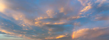 Dramatic sunset sky covered by gentle golden colored cloudの写真素材