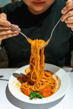 Vertical photo of young woman eating Spaghettiの写真素材