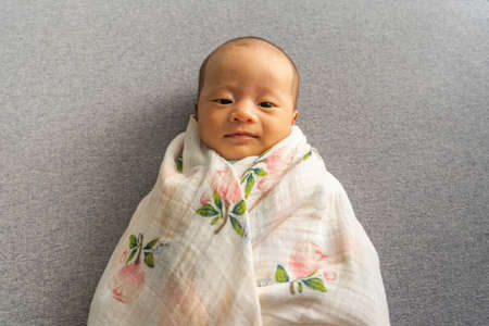 Portrait of lovely Asian baby girl on grey backgroundの写真素材