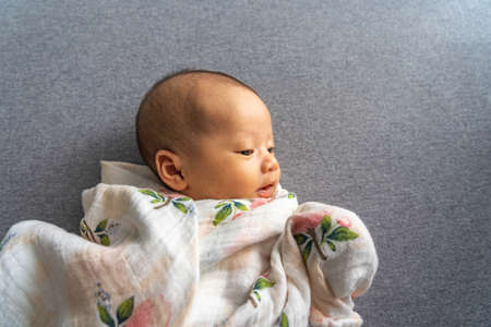 Happy new born baby girl on gray backgroundの写真素材