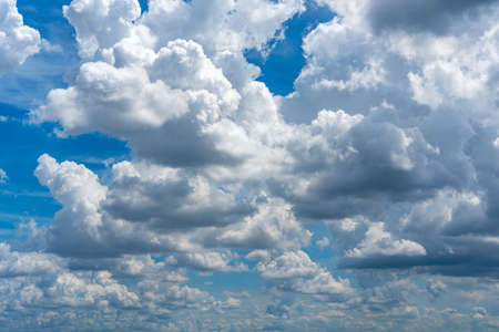 Lots of cumulus clouds far blue daylight sky as natural backgroundの写真素材