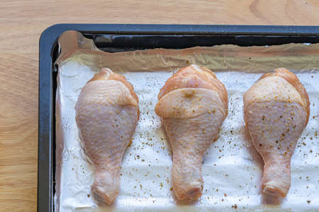 Raw chicken legs isolated on aluminium foilの写真素材