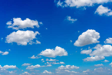 White cumulus clouds floating in the blue skyの写真素材