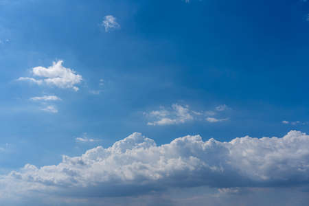 White cumulus clouds floating in the blue skyの写真素材