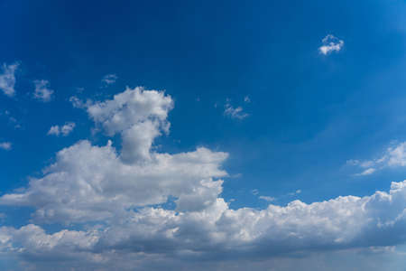White cumulus clouds floating in the blue skyの写真素材