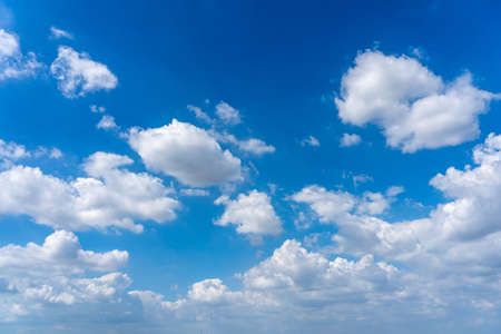 Blue sky background with many cumulus cloudsの写真素材