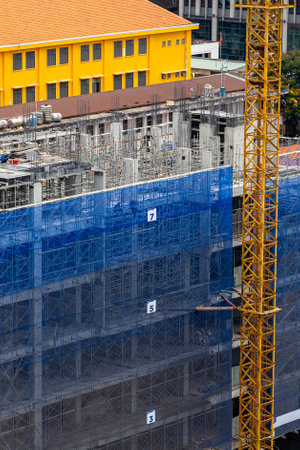 Vertical photo of new construction site with crane and mechanical equipmentsの写真素材