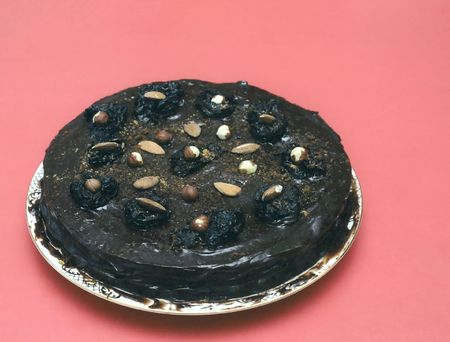 Black chocolate cake with nuts on redの写真素材