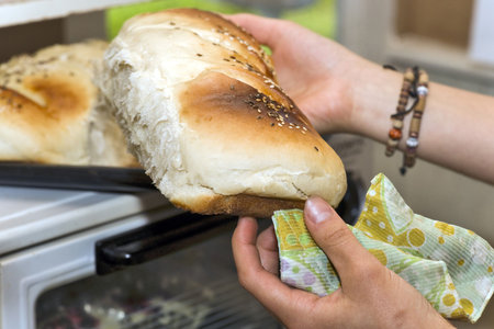 Baker woman hands with baguette of white bread