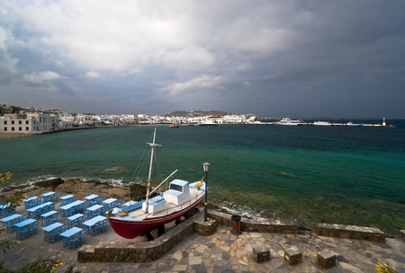 Mykonos port view and taverna in front with blue furnitureの写真素材