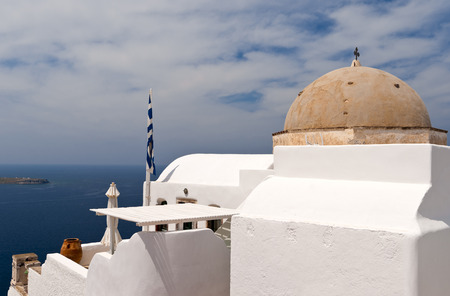 Greek church with bell-tower, national flags and sea view in spring dayの写真素材