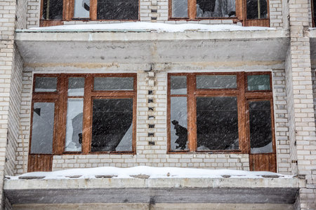 Broken windows of destroyed abandoned house, winter