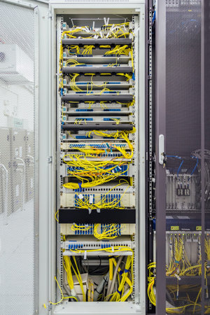 Inside the cabinet with switchboard and other telecommunication mobile network equipment with many...
