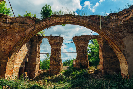 Ruins of church of Michael the Archangel in Yelets, overgrown arc of red brick and ruined columns