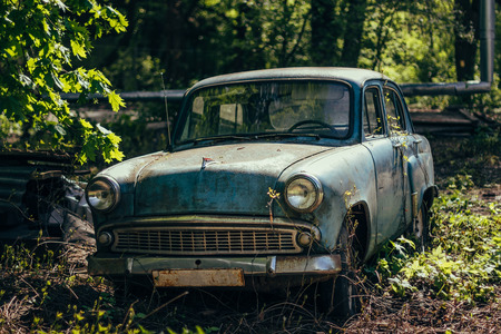 Old rusty overgrown abandoned soviet retro carの写真素材