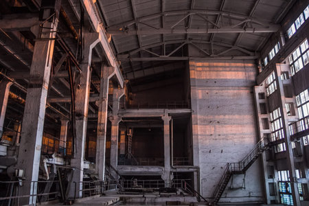 Dark industrial interior of large empty hall for manufacturing or warehousing. Abandoned factory.