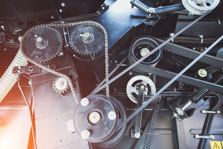 Mechanism of new modern agricultural combine harvester. Gears with chain drive, pulleys with drive belts. Industrial mechanical background. Tonedの写真素材