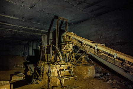 Abandoned limestone mine. Old rusty stone cracking and loading equipment with conveyor belt.の写真素材