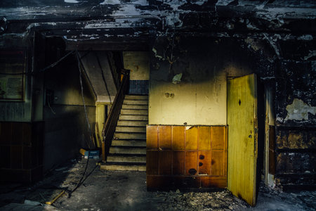 Burned by fire interior of old hospital. Charred walls and doors of corridor.
