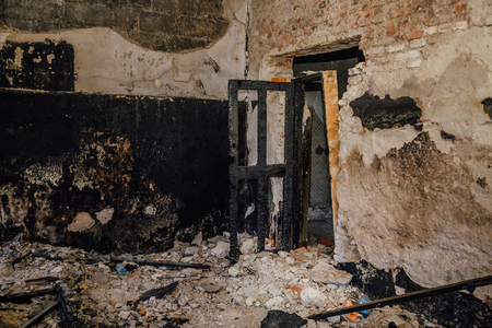 Burned room interior in apartment house. Burned door and charred walls.の写真素材