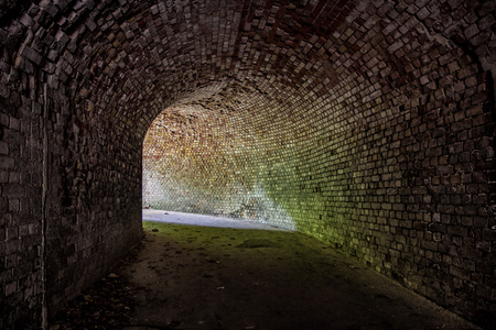 Underground vaulted red brick tunnel under abandoned German fortress. Turn the tunnelの写真素材
