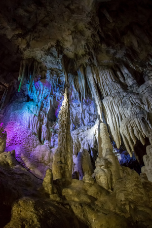 Big Azishskaya cave with speleothem, stalactites, stalagmites and stalagnates in Adygeya illuminated by colored lanternsの写真素材