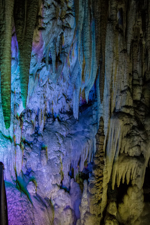 Big Azishskaya cave with speleothem, stalactites, stalagmites and stalagnates in Adygeya illuminated by colored lanternsの写真素材