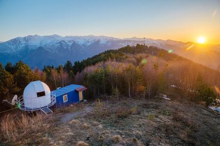 Small astronomical observatory with telescope in Caucasian mountains at the sunset.の写真素材