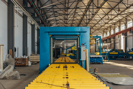 Roller conveyor and packing machine in metal profile panel workshopの写真素材