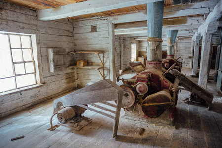 Inside old abandoned wooden mill with old equipment.