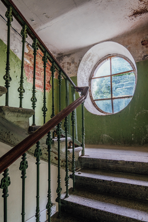 Old vintage staircase at the old house. Oval window.の写真素材