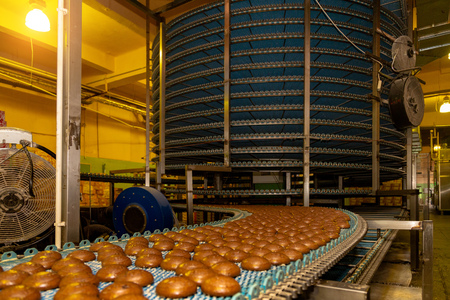 Large automated round conveyor machine in bakery food factory, cookies and cakes production line.の写真素材