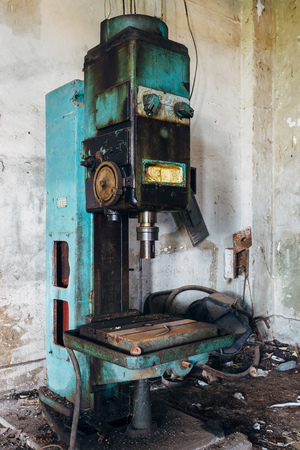 Old rusty industrial drilling machine  in abandoned factory workshop looks like robot.の写真素材