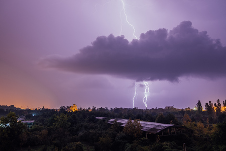 Lightning strikes during thunderstorm over the city.の写真素材