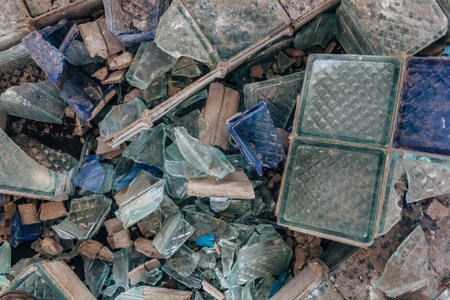Shards of broken glass on dirty floor.