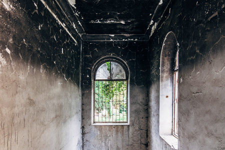 Burnt mansion interior. Broken windows, walls in black soot.の写真素材