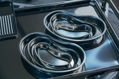 Stainless steel surgical Instrument trays of various sizes on steel tableの写真素材