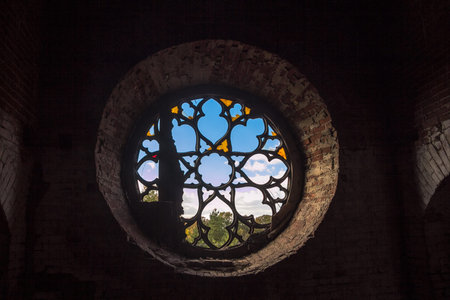 Round castle window with broken stained-glass windows